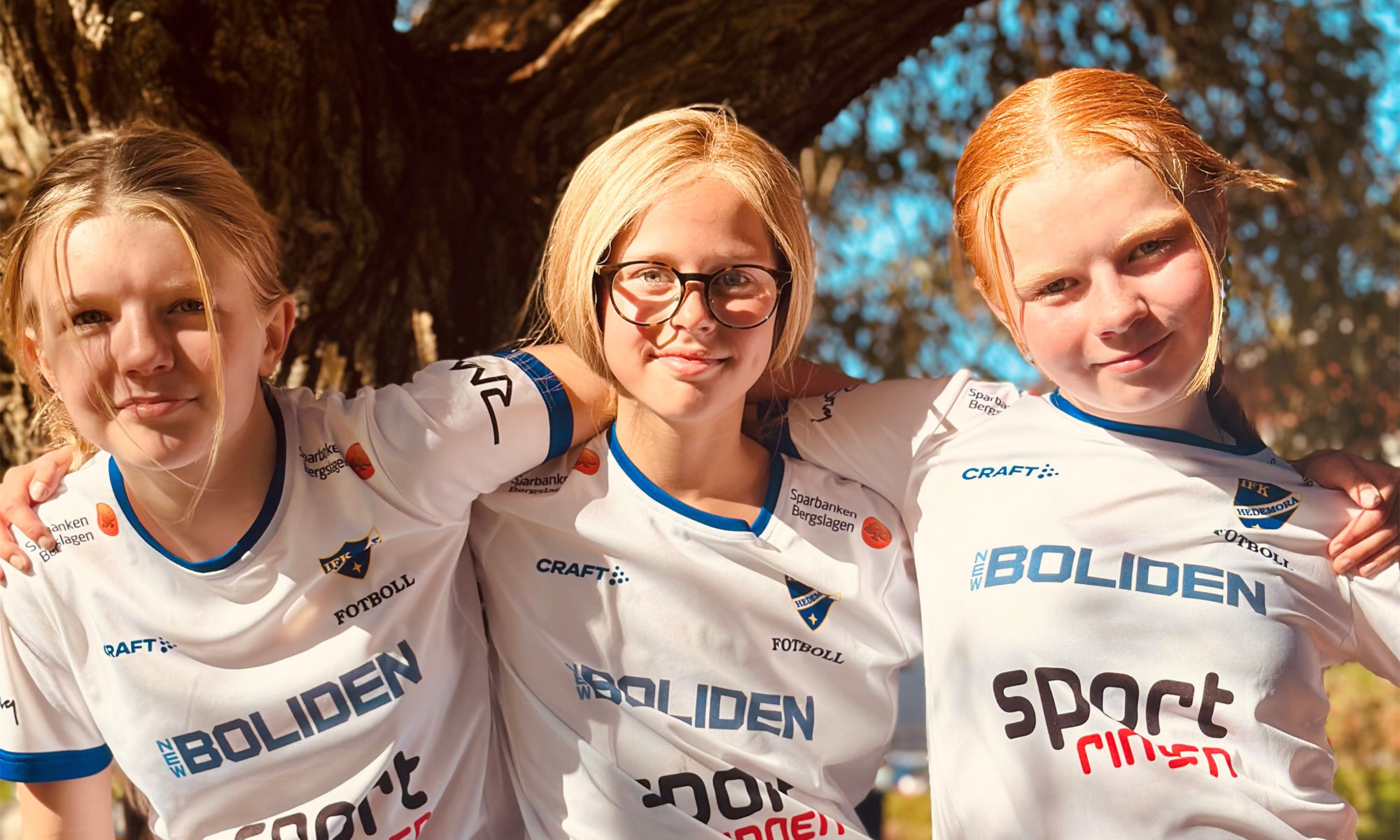 Three girls from IFK Hedemora F14 holding each other and looking into the camera