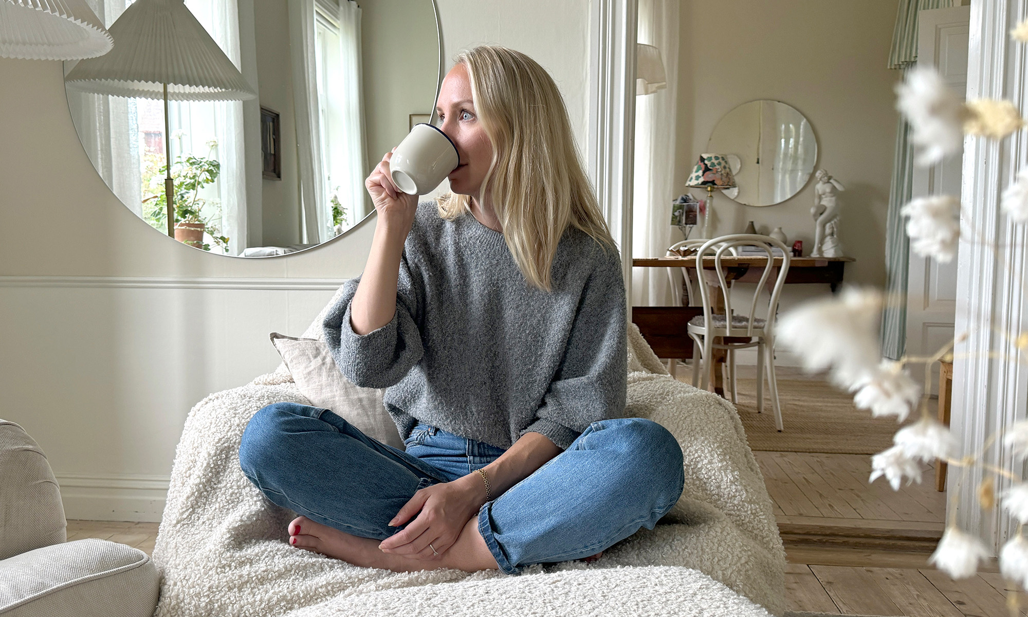 Woman sitting on fluffy armchair enjoying a cup of coffee